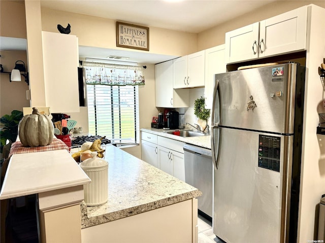 kitchen with white cabinetry, sink, and stainless steel appliances