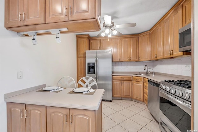 kitchen with backsplash, sink, ceiling fan, light tile patterned floors, and appliances with stainless steel finishes