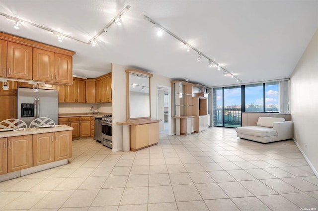 kitchen featuring light tile patterned floors, stainless steel appliances, and track lighting