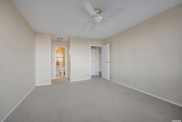 unfurnished bedroom featuring light carpet, ensuite bath, and ceiling fan