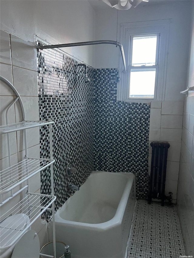 bathroom with radiator, tile walls, and toilet