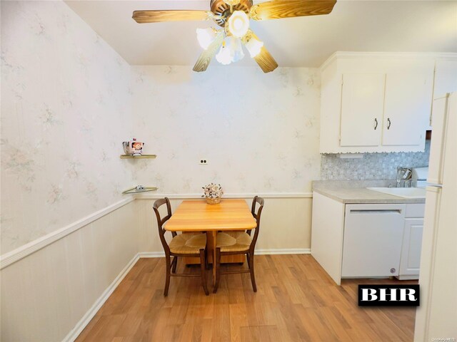 dining room featuring ceiling fan, light wood-type flooring, and sink