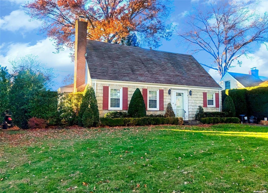 cape cod house with a front lawn