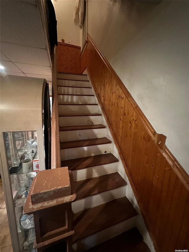 stairs featuring wood walls