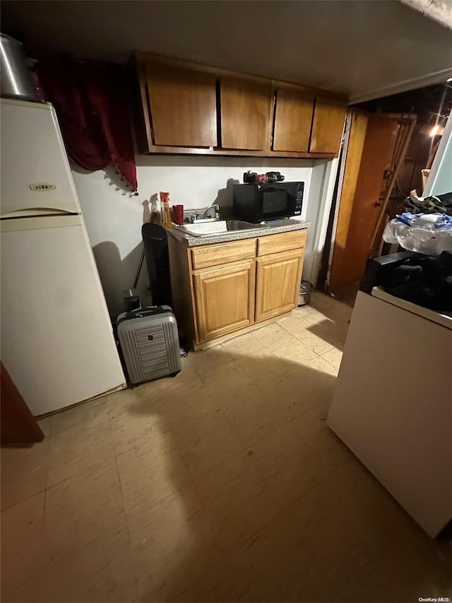 kitchen featuring sink and white fridge