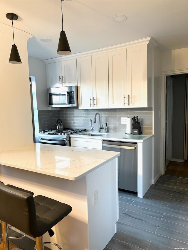 kitchen featuring backsplash, sink, white cabinetry, and stainless steel appliances