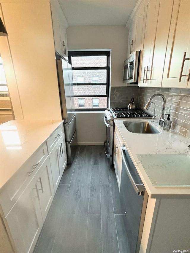 kitchen featuring white cabinetry, sink, light stone countertops, dark hardwood / wood-style floors, and appliances with stainless steel finishes