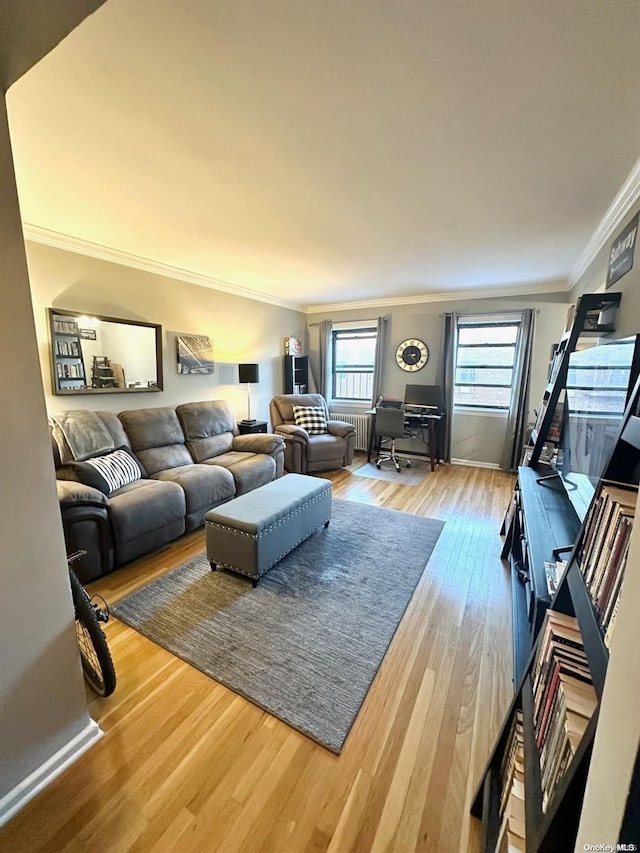 living room with radiator heating unit, hardwood / wood-style flooring, and ornamental molding