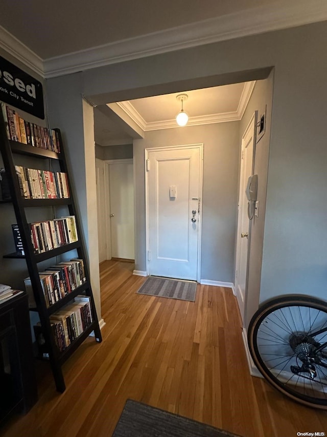 doorway to outside with crown molding and wood-type flooring