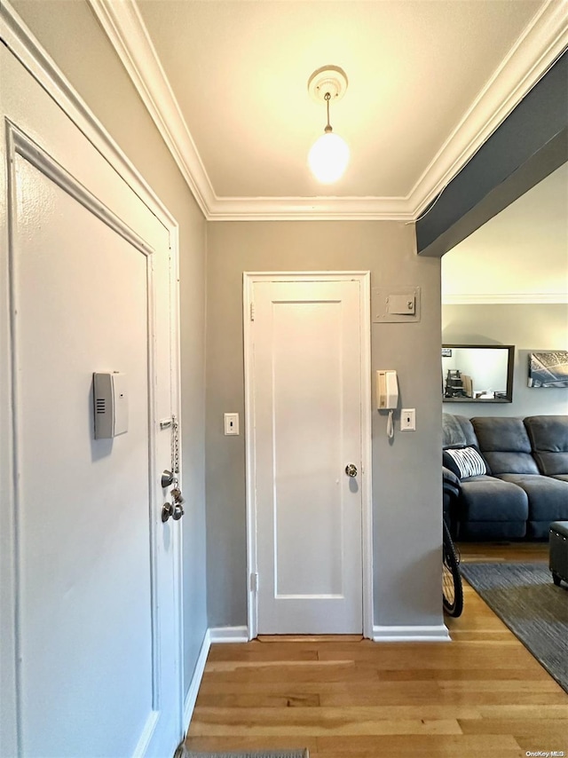 entryway featuring wood-type flooring and ornamental molding