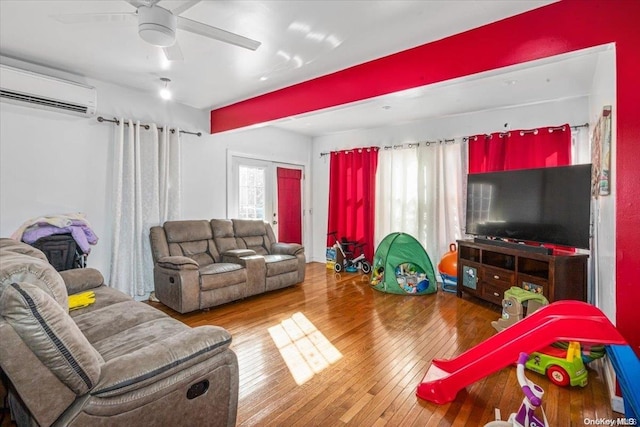 living room with hardwood / wood-style flooring, ceiling fan, and a wall mounted AC