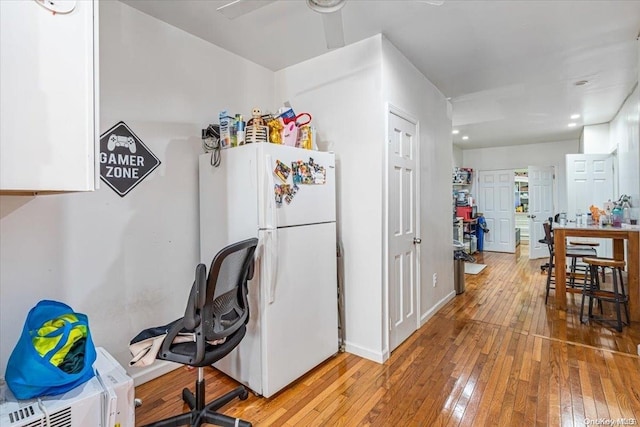 kitchen featuring ceiling fan, white fridge, and wood-type flooring