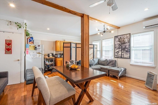 dining room with an AC wall unit, ceiling fan with notable chandelier, and light wood-type flooring