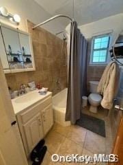 full bathroom featuring tile patterned flooring, shower / bath combo, vanity, and toilet