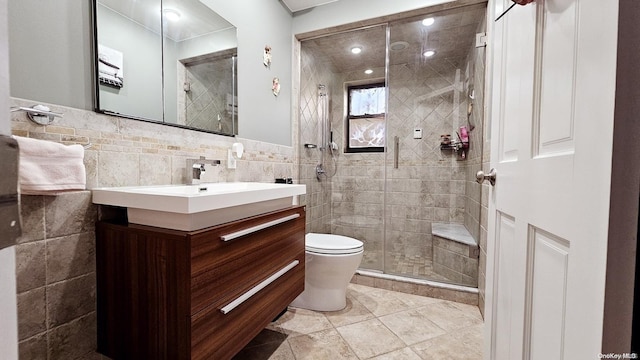 bathroom featuring walk in shower, vanity, tile walls, and toilet