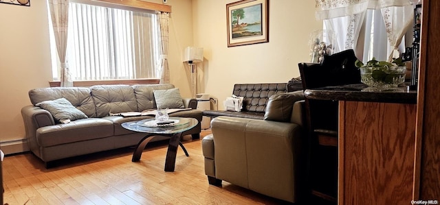 living room with baseboard heating and light hardwood / wood-style flooring