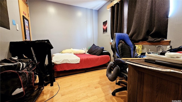 bedroom featuring light wood-type flooring and lofted ceiling