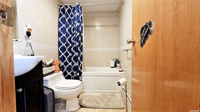 full bathroom featuring shower / bath combo, tile patterned floors, vanity, tile walls, and toilet