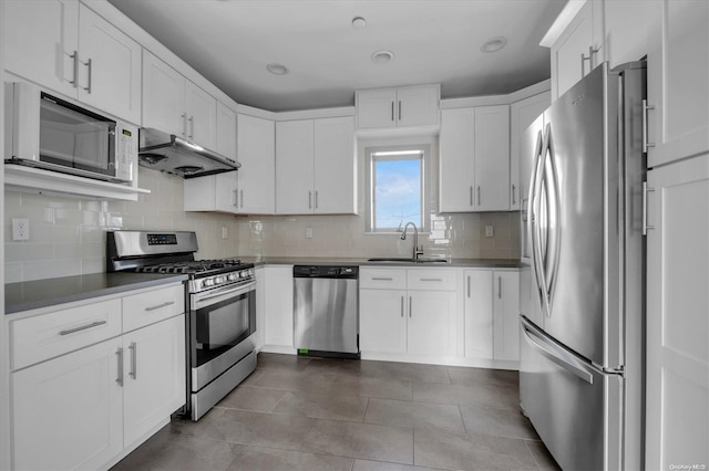 kitchen featuring decorative backsplash, stainless steel appliances, sink, light tile patterned floors, and white cabinets