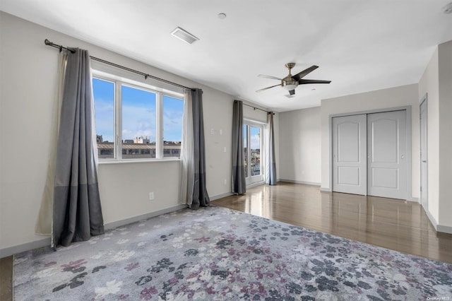 unfurnished bedroom featuring a closet, dark hardwood / wood-style floors, and ceiling fan