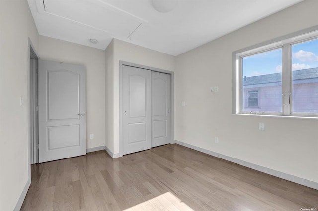 unfurnished bedroom featuring light hardwood / wood-style floors and a closet