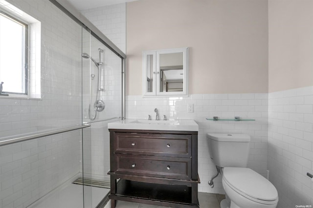 bathroom with an enclosed shower, vanity, toilet, and tile walls