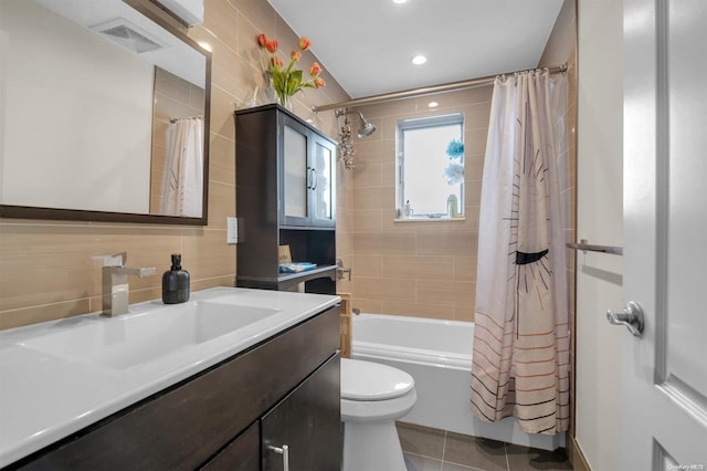 full bathroom with toilet, shower / bath combination with curtain, tile patterned floors, and tile walls