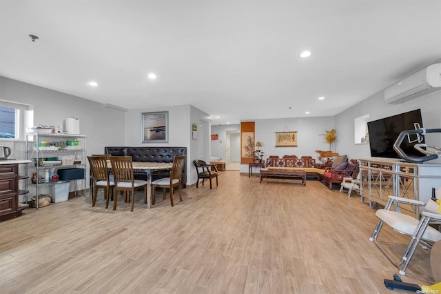 dining area featuring a wall mounted AC and light hardwood / wood-style floors