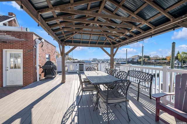 wooden deck with a gazebo, a water view, and grilling area