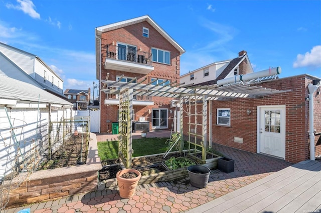 back of house featuring a pergola, a balcony, and a patio