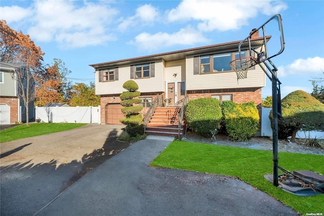 bi-level home featuring a garage and a front yard