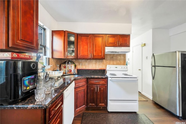 kitchen featuring decorative backsplash, white appliances, dark wood-type flooring, and dark stone counters