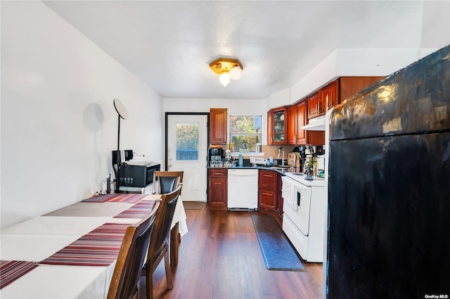 kitchen featuring stove, dark wood-type flooring, white dishwasher, black fridge, and sink