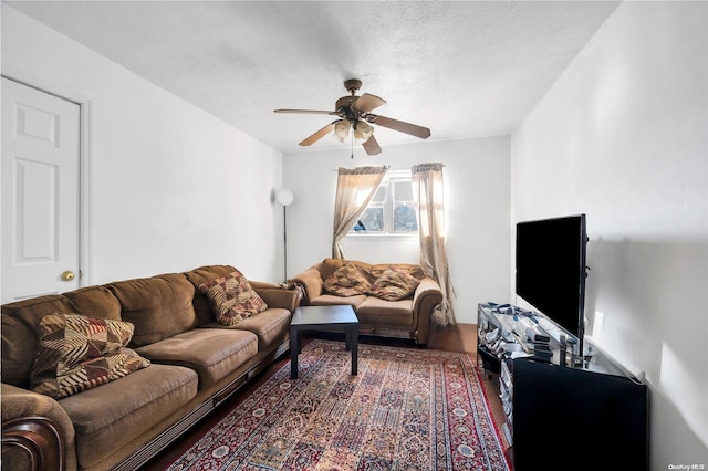 living room featuring ceiling fan, wood-type flooring, and a textured ceiling