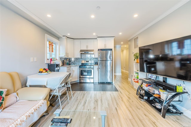 kitchen featuring backsplash, white cabinets, crown molding, light wood-type flooring, and appliances with stainless steel finishes