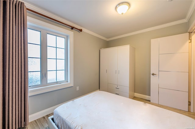 bedroom with crown molding, a closet, and light hardwood / wood-style floors