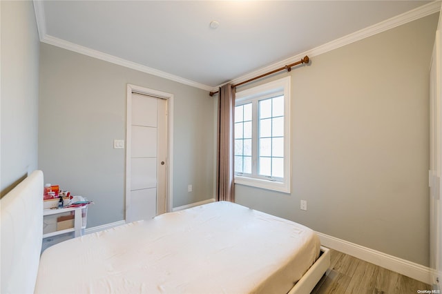 bedroom featuring hardwood / wood-style flooring and crown molding