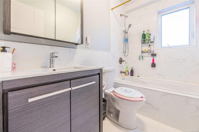 full bathroom with tile patterned floors, vanity, tiled shower / bath combo, tile walls, and toilet