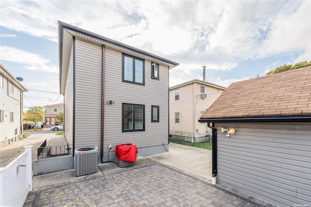 rear view of house with cooling unit and a patio