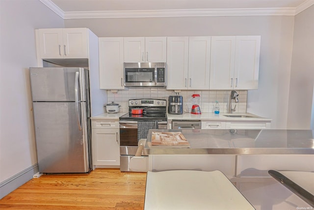 kitchen featuring crown molding, sink, light wood-type flooring, appliances with stainless steel finishes, and white cabinetry