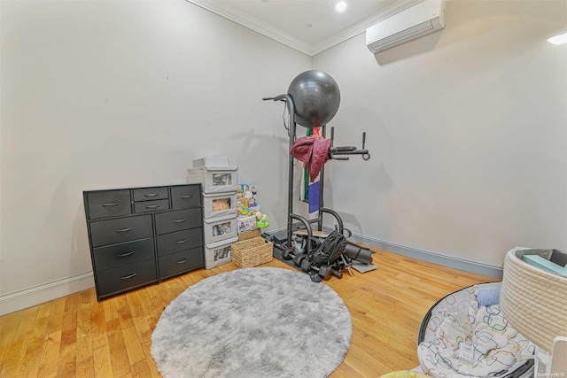 exercise room with a wall unit AC, hardwood / wood-style floors, and ornamental molding