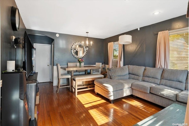 living room with dark hardwood / wood-style flooring and an inviting chandelier