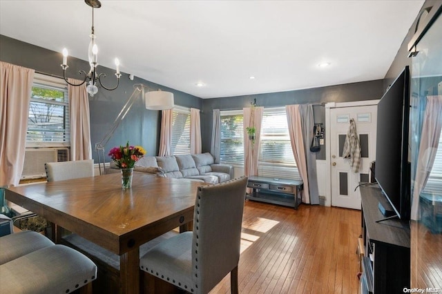 dining area featuring an inviting chandelier, a wealth of natural light, and light hardwood / wood-style flooring