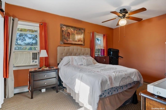 bedroom featuring light carpet, ceiling fan, and a baseboard heating unit