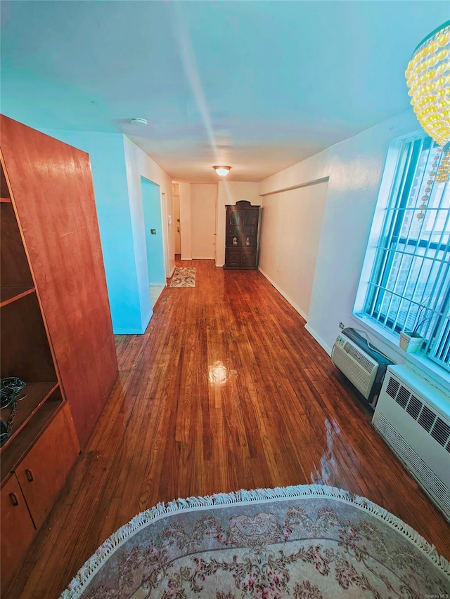 hall with dark hardwood / wood-style floors, an AC wall unit, and radiator