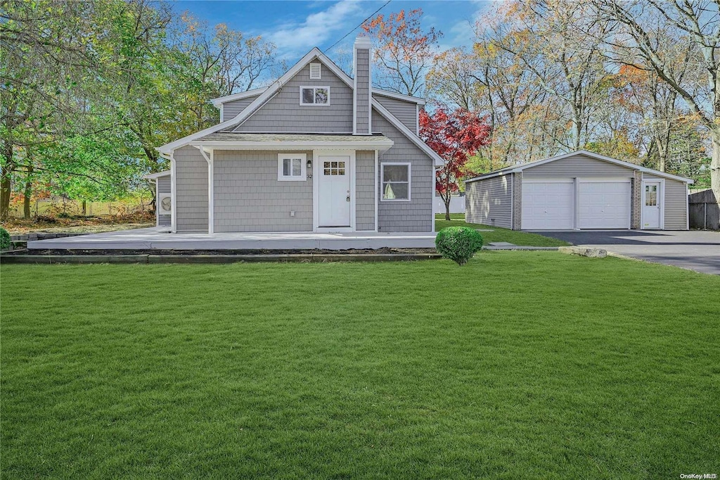 view of front facade with a front lawn, an outdoor structure, and a garage