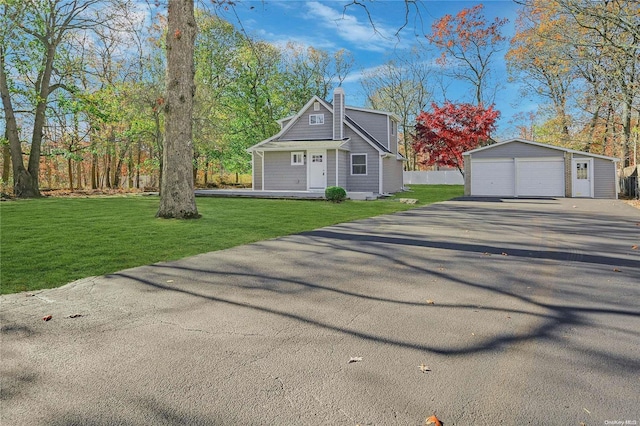 view of front of home featuring a garage, an outdoor structure, and a front lawn