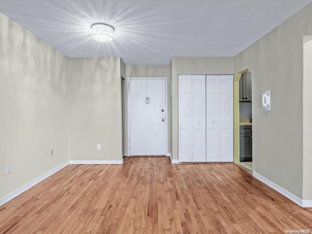 unfurnished bedroom with a textured ceiling and light hardwood / wood-style floors