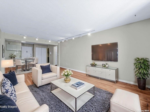 living room featuring hardwood / wood-style floors, a textured ceiling, and track lighting