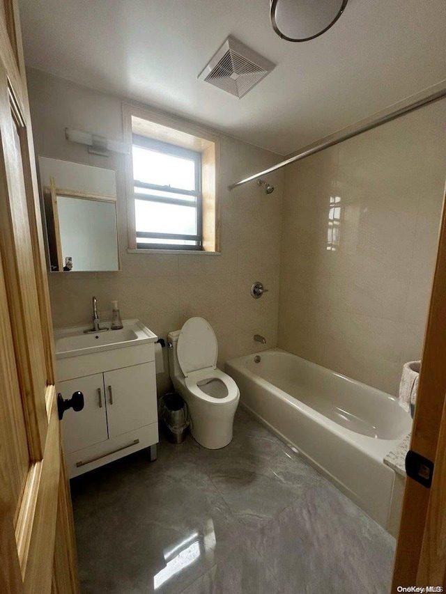 full bathroom with tiled shower / bath combo, toilet, and vanity